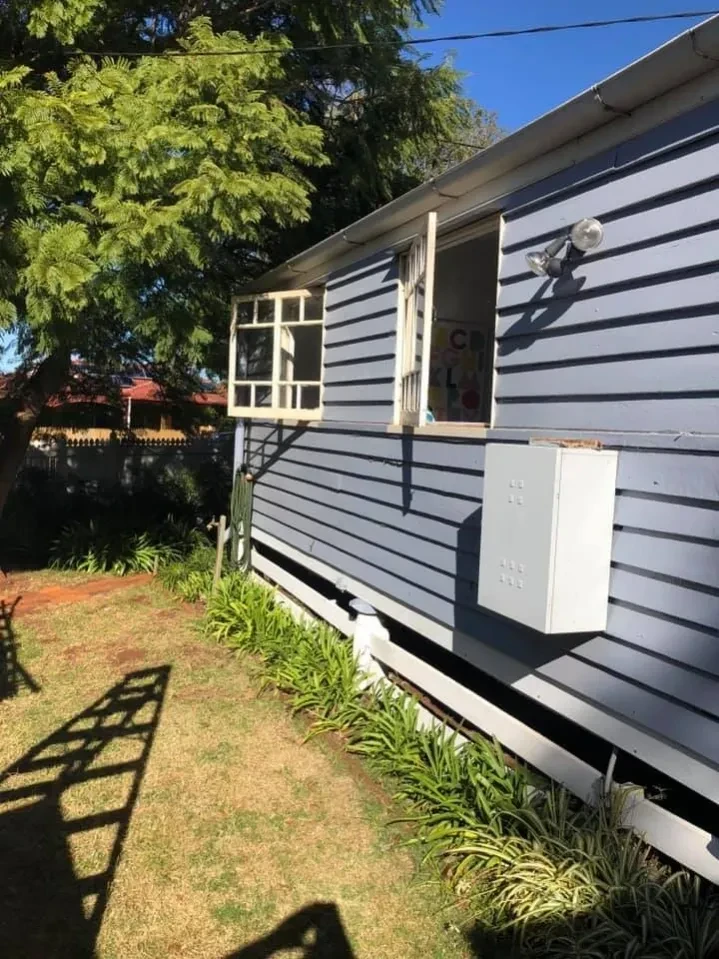 Blue weatherboard house with white picket fence